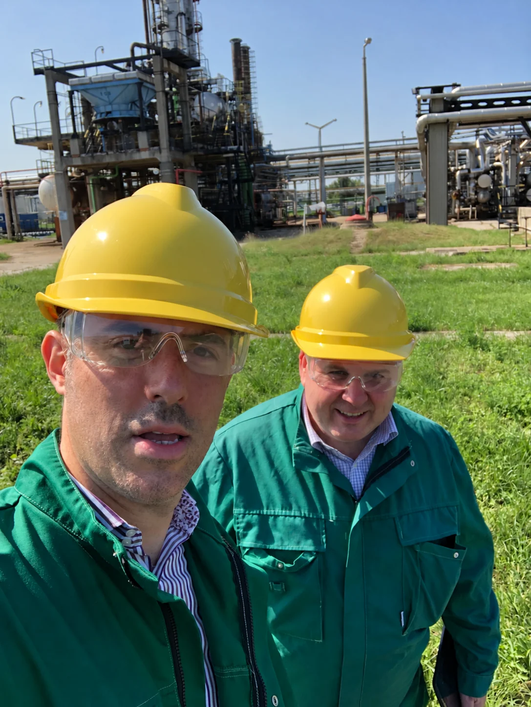 Infotechnics directors Jon and Brian wearing hard hats and safety glasses during a plant visit.